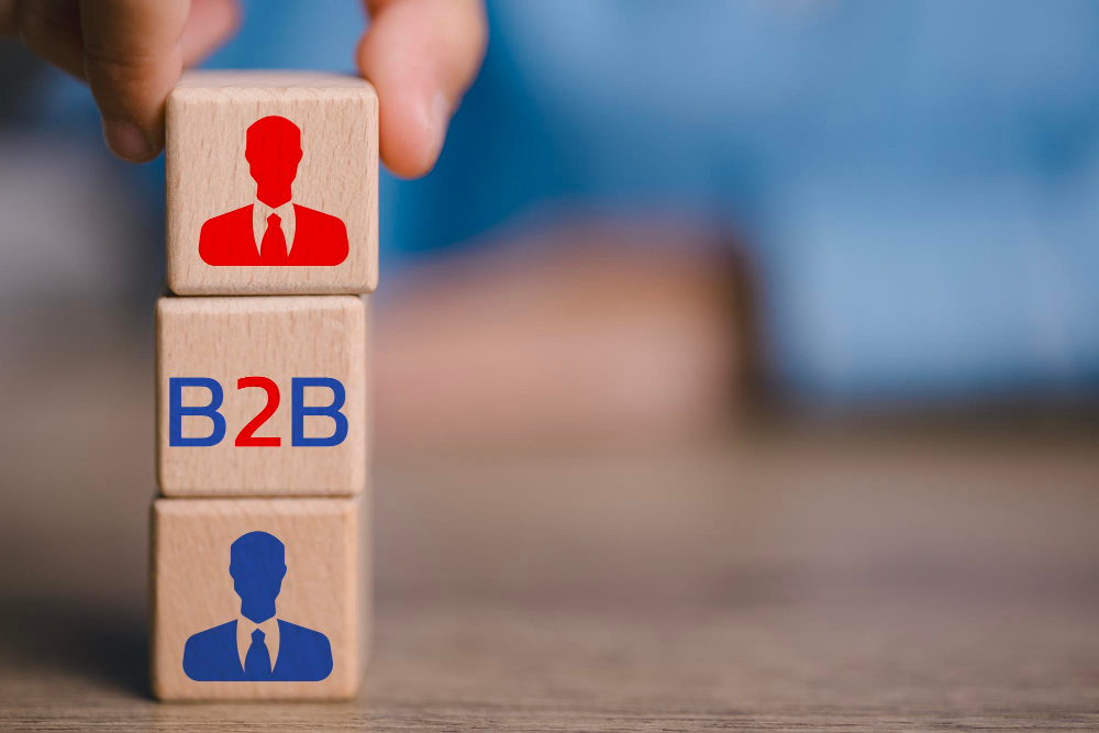 B2B concept shown on wooden cubes with businessmen icons in blue and red