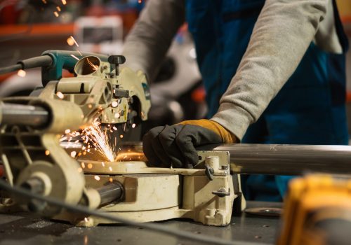 Technician worker cutting metal with many sharp sparks. Using equipments to cat iron